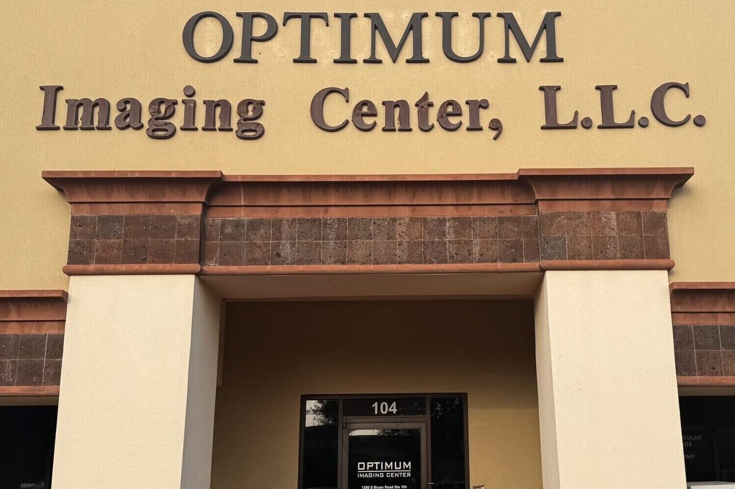 Entrance of Optimum Imaging Center with glass door and signage.