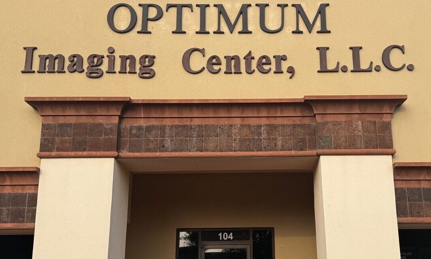 Entrance of Optimum Imaging Center with glass door and signage.